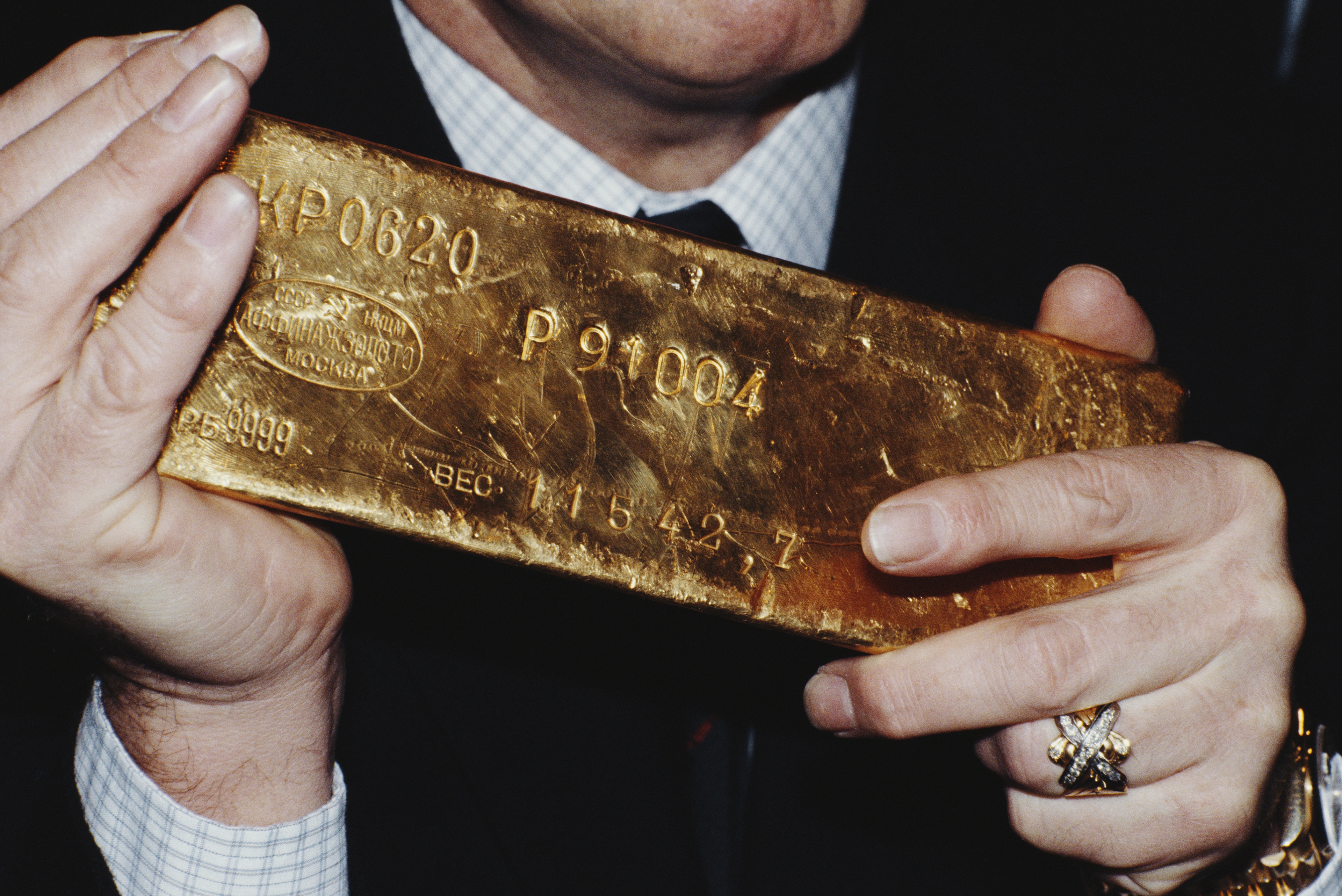 A man holding a gold bar.