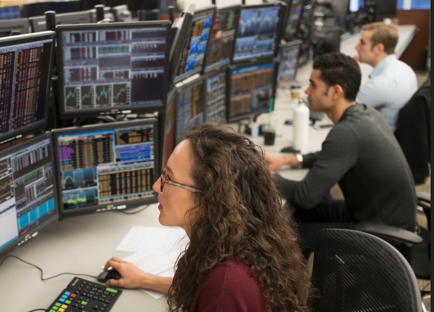 Traders study their monitors