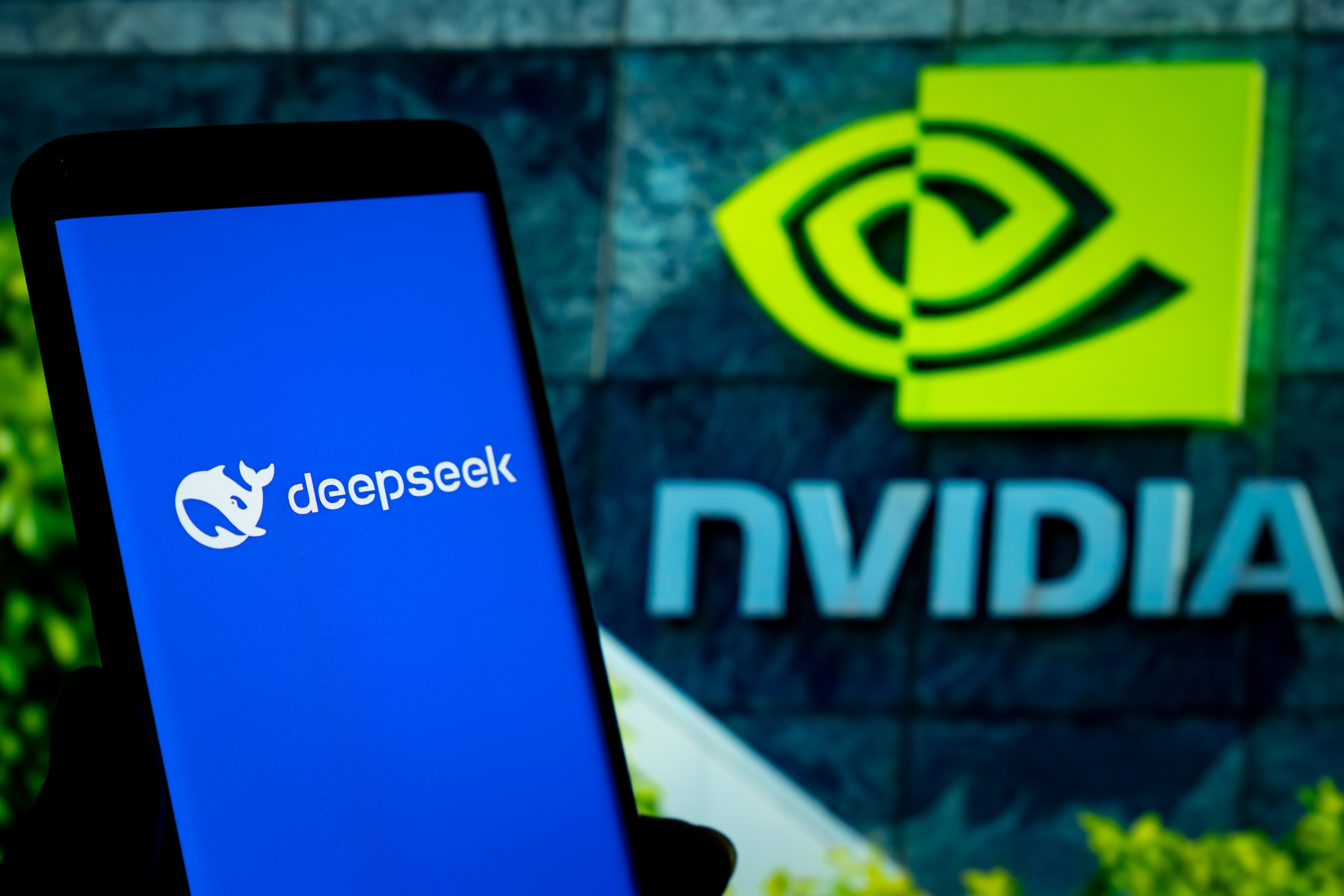 A phone with the DeepSeek logo on it, in front of an Nvidia logo.