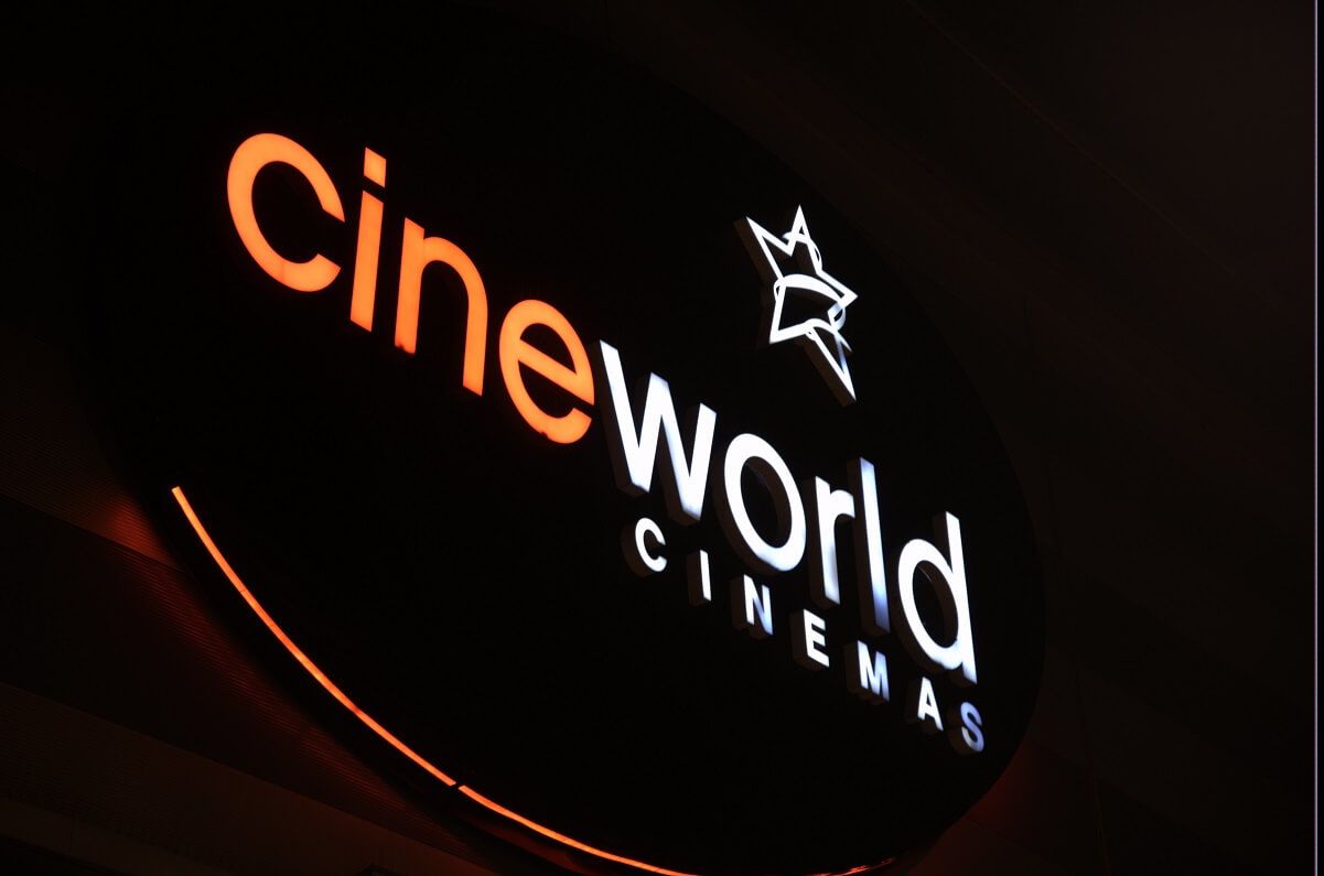 Cineworld share price: a Cineworld sign glows at the entrance to one of its cinemas.