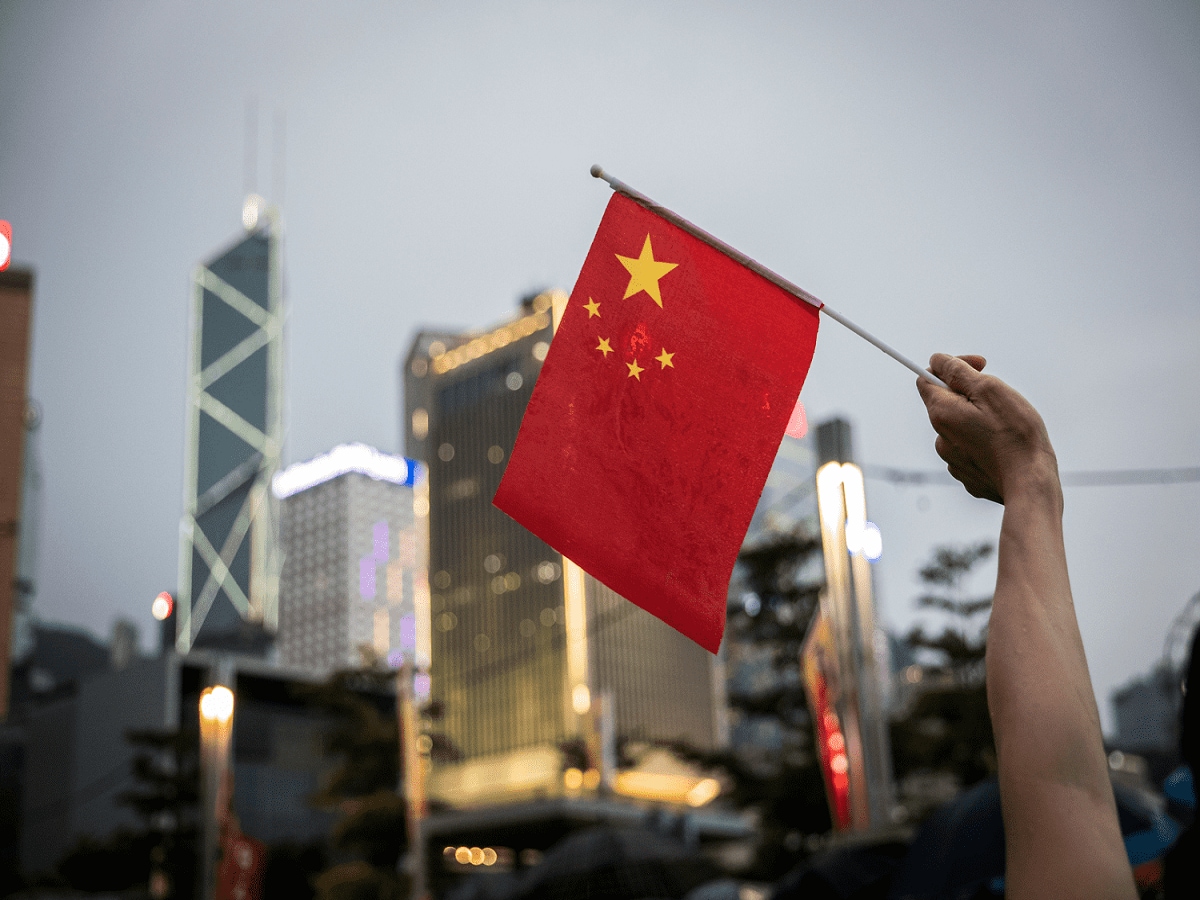 A hand holding a Chinese flag.