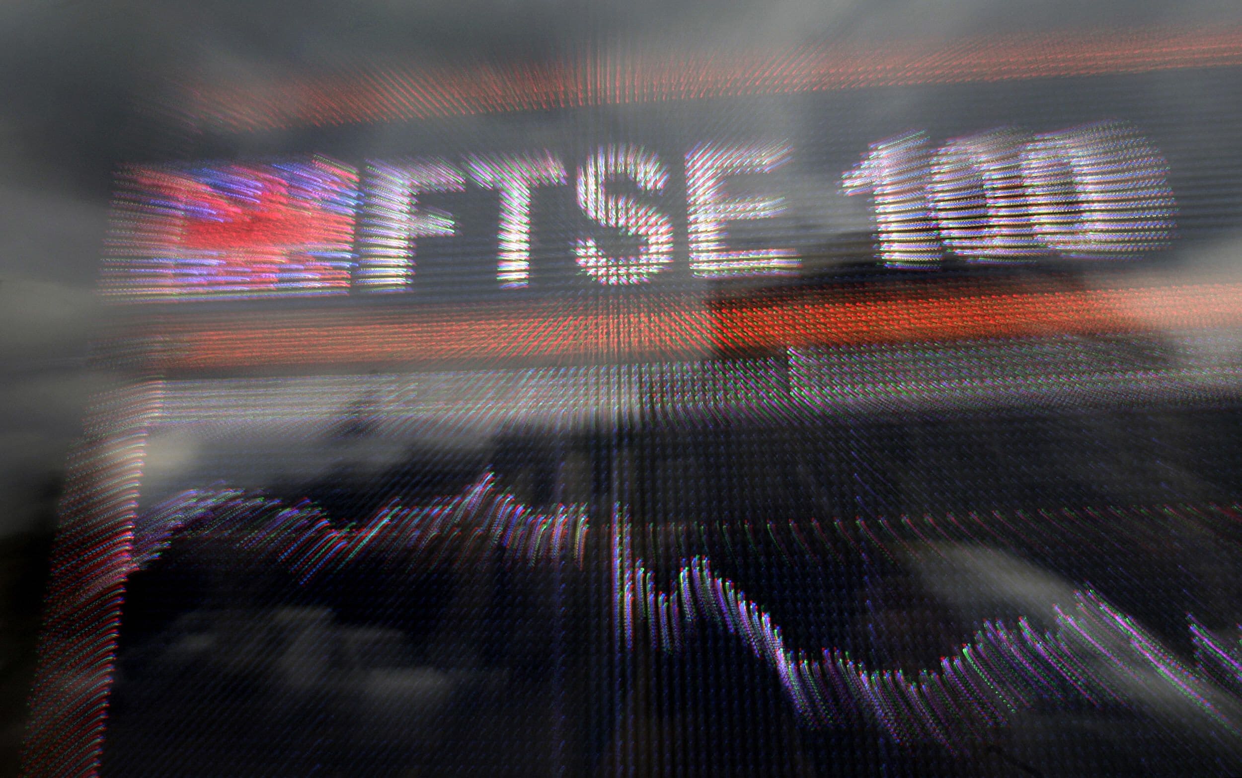 A FTSE 100 stock board with fluctuating price action