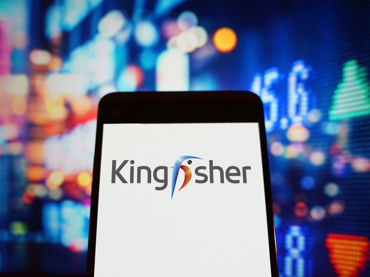 Kingfisher logo on a mobile device in front of a trading screen