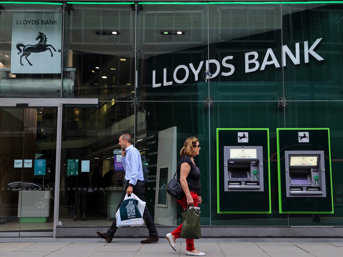 Lloyds share price: People walk past a branch of Lloyds bank