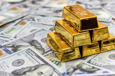 lingotes de oro encima de billetes de dólar