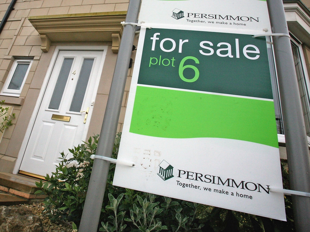Persimmon share price: A Persimmon-branded 'for sale' sign is displayed outside one of its homes.