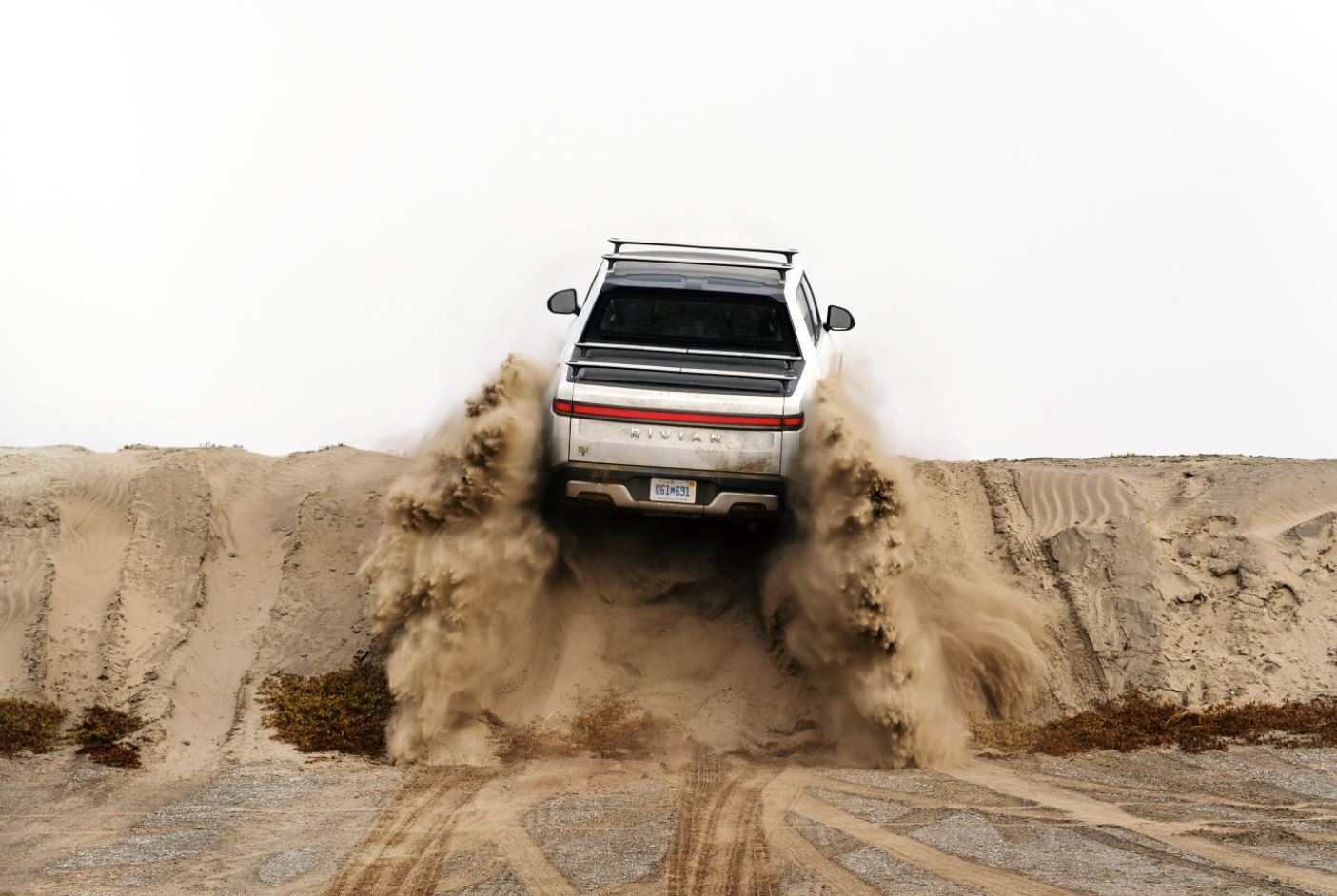 Rivian truck climbing a sandhill