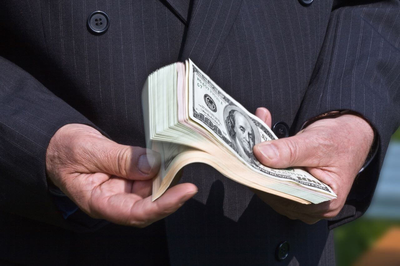 Businessman fanning through a handful of dollar