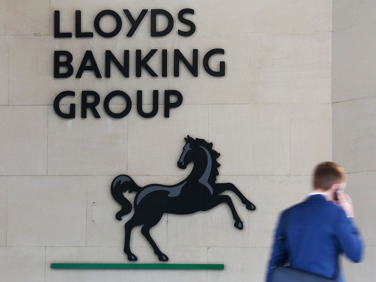 Lloyds share price: A man walks past the offices of Lloyds Banking Group.