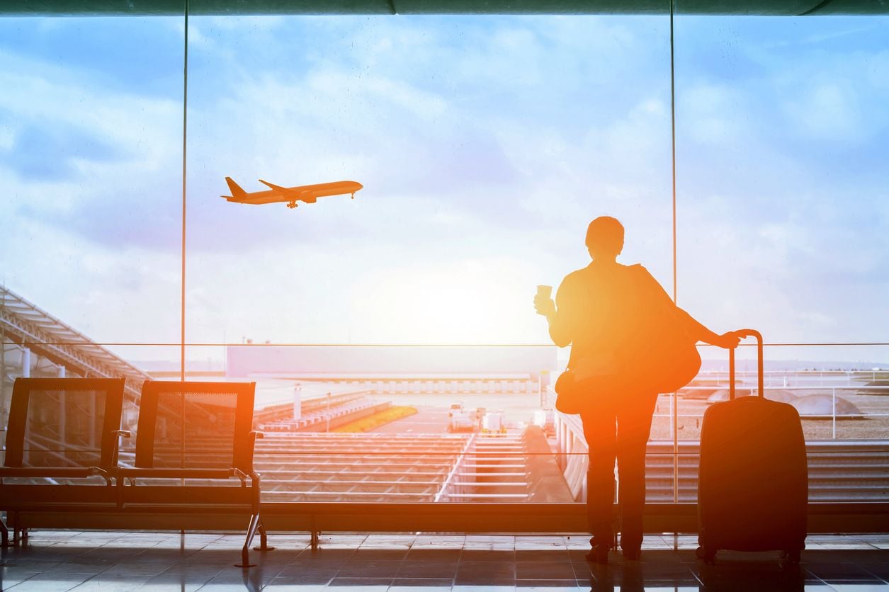 man preparing to travel at airport wanderlust buy travel stocks