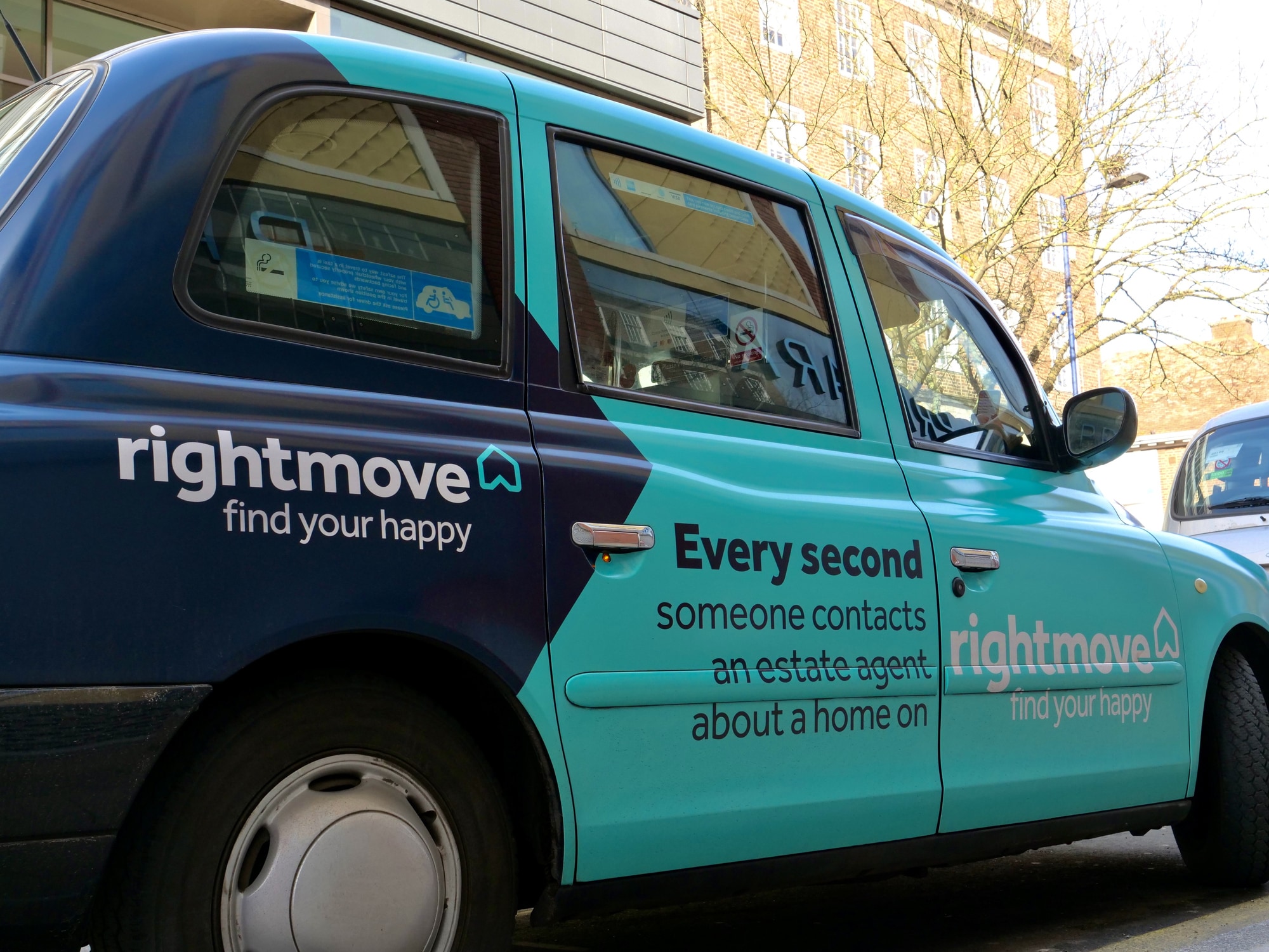 A london taxi with Rightmove advert on the side